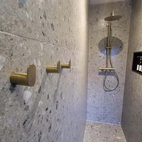 A luxurious shower with a shiny brass shower head